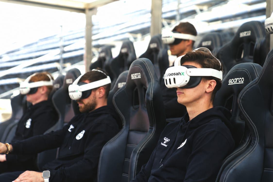 Athletes wearing WoosahX headsets in stadium seats