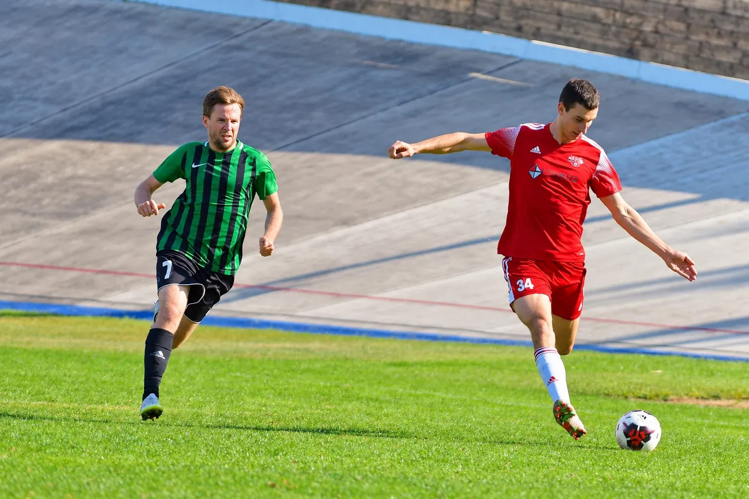 Michal Provod in red preparing to strike the ball on a football pitch.