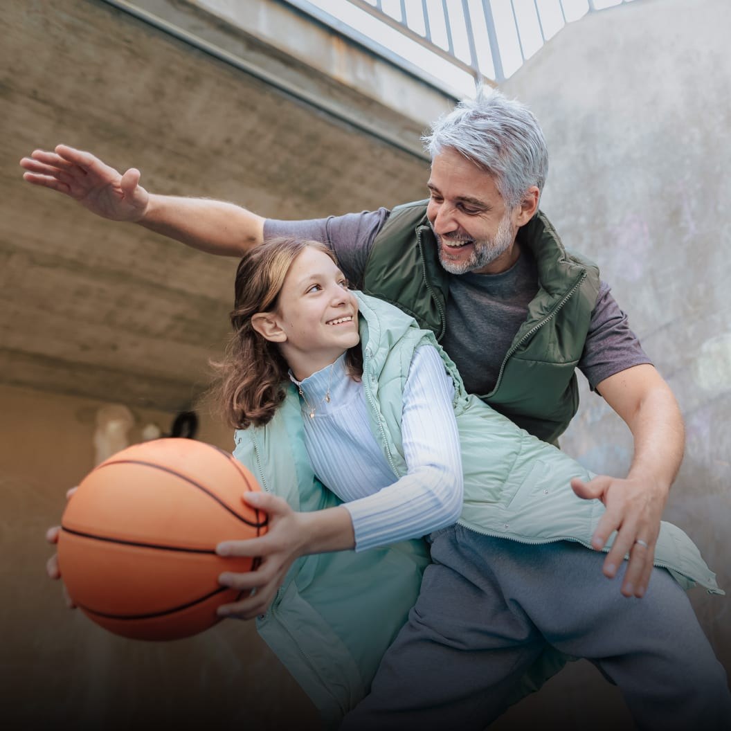 Father encouraging his daughter during basketball practice