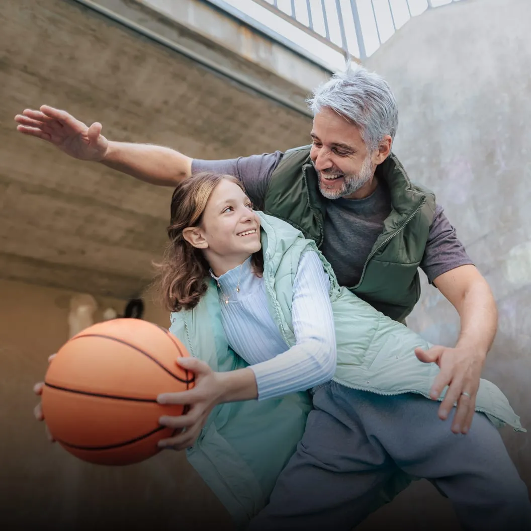 Parent encouraging a young basketball player